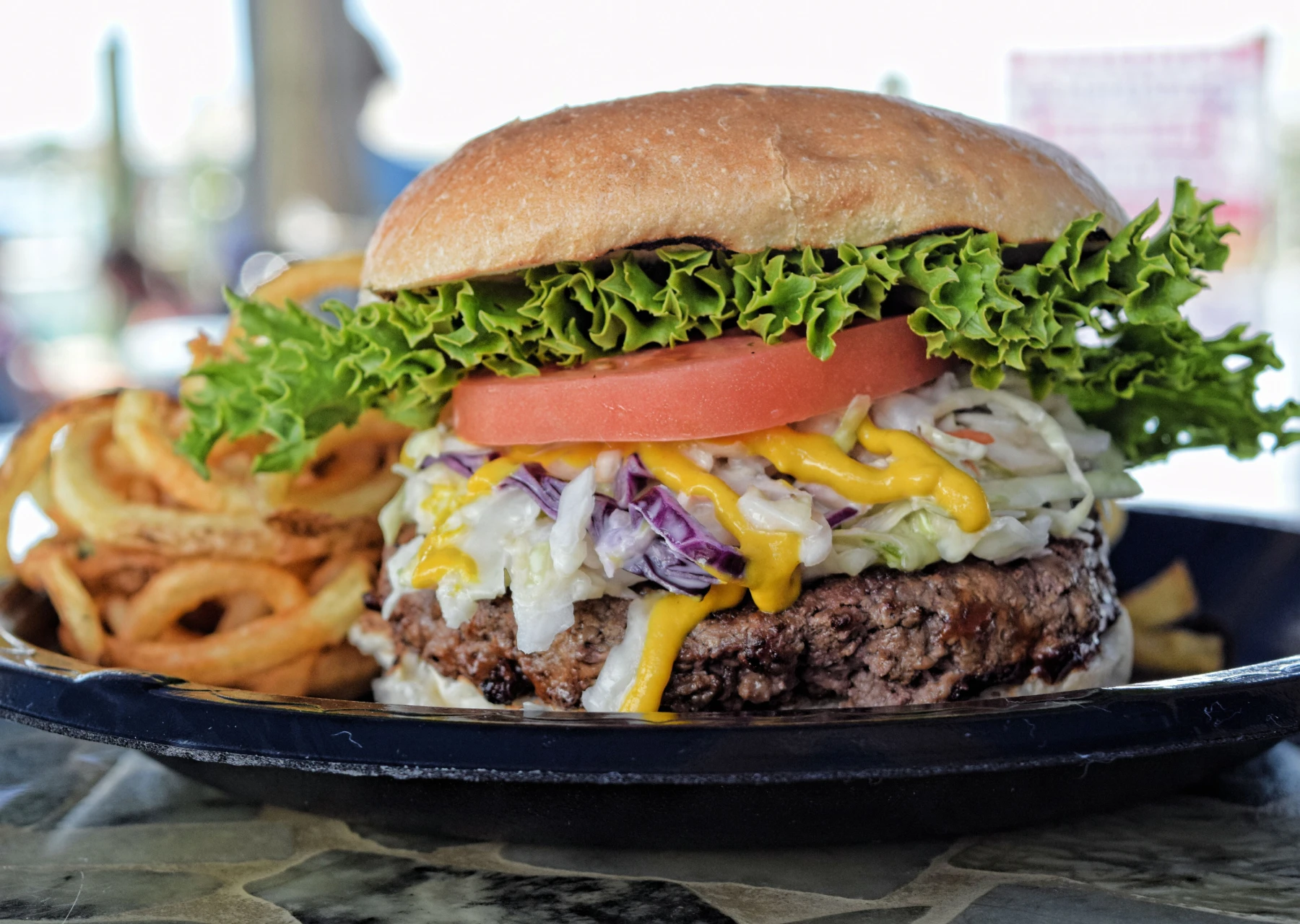 A Juicy Burger with Cole Slaw and a Side of Curly Fries at SmacNallys Waterfront Bar and Grill - Hero