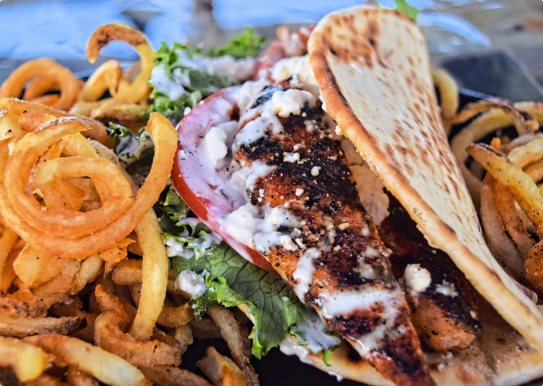 Blackened Chicken Pita with a Side of Curly Fries at SmacNallys Waterfront Bar and Grill - Hero