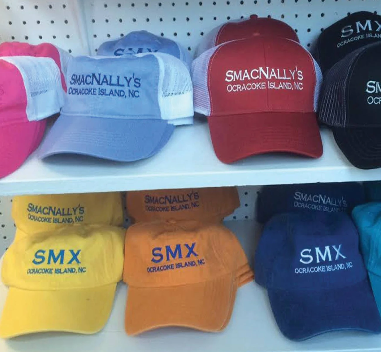 Various hats with SmacNallys Waterfront Bar and Grill logo on them